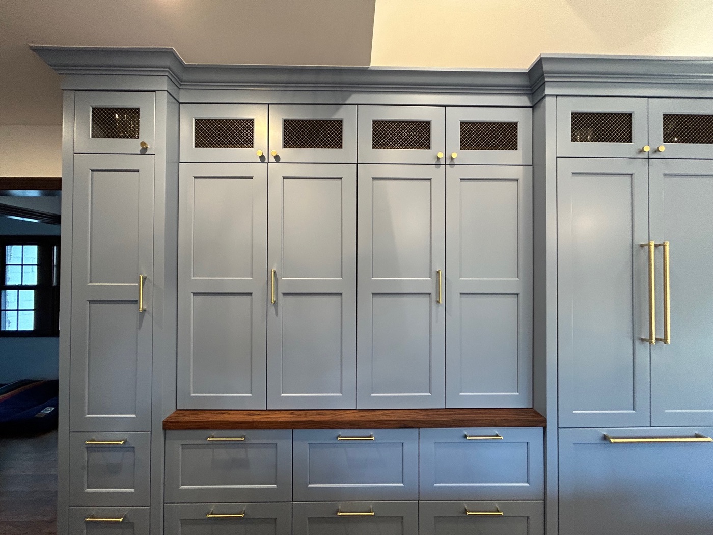 Blue-gray mudroom built-ins with walnut countertop